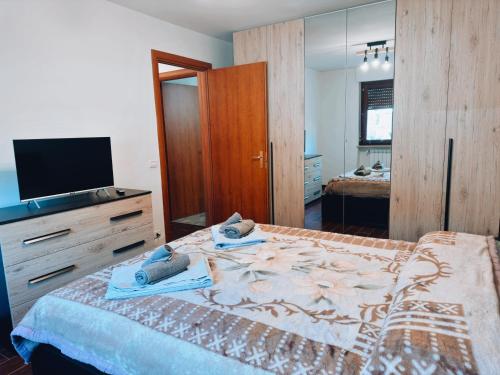 a bedroom with a bed with a dresser and a television at Finestra su Villalago in Villalago
