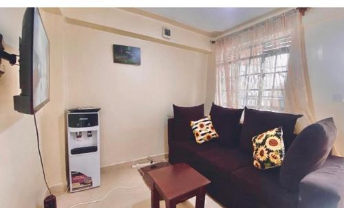 a living room with a couch and a television at Zuri Furnished Apartment in Bomet