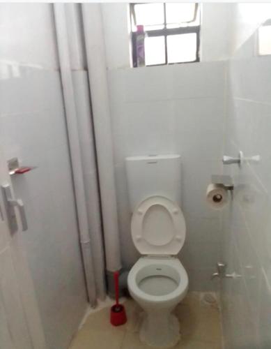 un piccolo bagno con servizi igienici e finestra di Faraja a Meru
