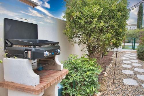 Una televisión o centro de entretenimiento en Divine ROUJAN Sunny Lodge