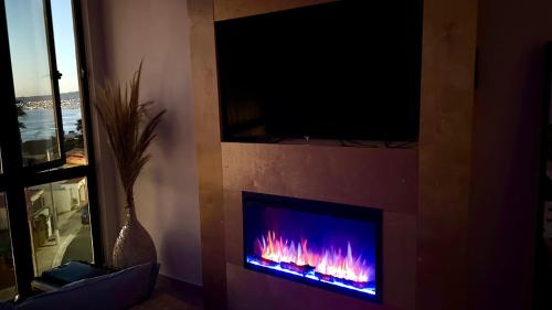 a living room with a fireplace with a fire in it at Luxury, Ocean View, Pool, Jacuzzi, Valle de Guadalupe, Los Portales De Garcia, Splash, Encanto Restaurants, Surf Breaks in Primo Tapia, Rosarito in Rosarito