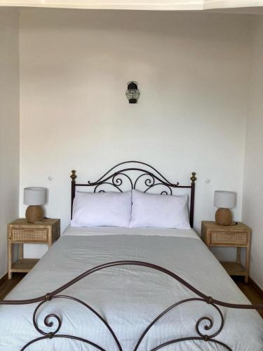 a bedroom with a large bed with two night stands at Casa da Nazaré in Portinho da Arrábida