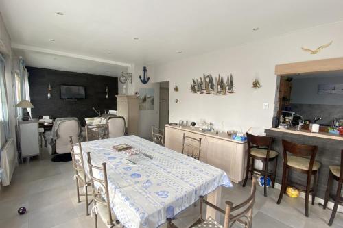 ein Esszimmer mit einem Tisch und einer Küche in der Unterkunft Family nest located in Hermanville-sur-mer in Hermanville-sur-Mer