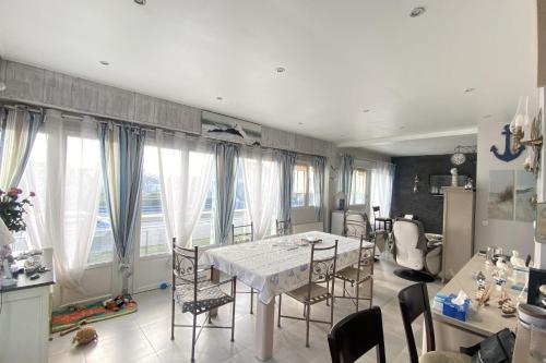eine Küche und ein Esszimmer mit einem Tisch und Stühlen in der Unterkunft Family nest located in Hermanville-sur-mer in Hermanville-sur-Mer