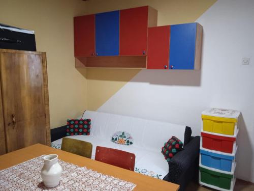 a dining room with a table and some colorful cabinets at Dedina Luka in Valjevo