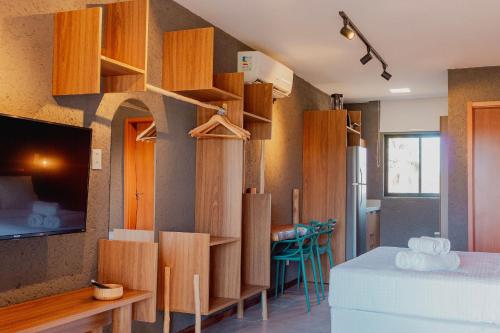 a room with wooden cabinets and a bed and a kitchen at Condomínio Gamboa Patacho a 190 da praia na Rota dos Milagres in Pôrto de Pedras