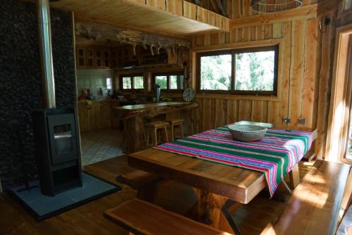 a wooden kitchen with a table and a stove at El Refugio de Hadas y Elfos in Puerto Fuy