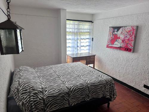 ein Schlafzimmer mit einem Zebra-Bett und einem Fenster in der Unterkunft APARTAMENTOS VERANERA in Río Oro