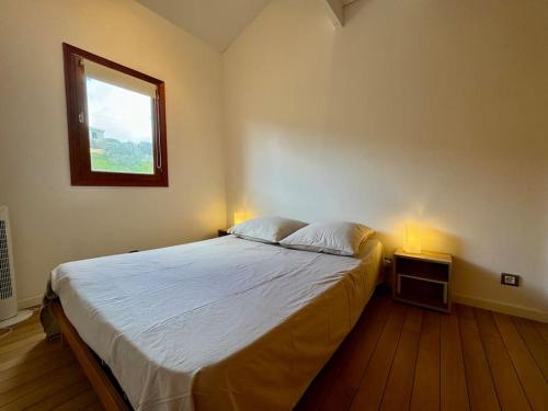 - une chambre avec un lit, une fenêtre et deux lampes dans l'établissement Appartement les pieds dans l'eau, à Calcatoggio