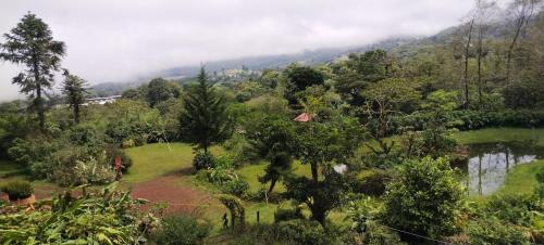 vistas a un valle con río y árboles en Finca Valle Arcoiris en Heredia