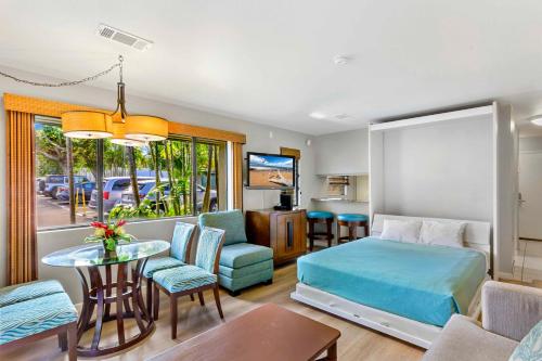 a bedroom with a bed and a living room at Gardens at West Maui in Lahaina
