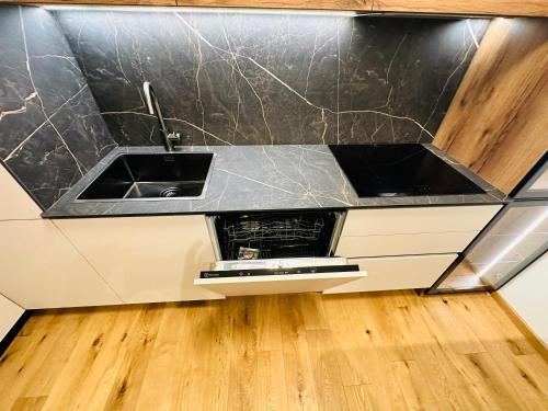 a kitchen with two sinks and a wooden floor at Apartman Aurora Self Check in in Zagreb