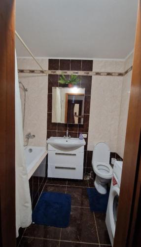 ein Badezimmer mit einem Waschbecken, einem WC und einem Spiegel in der Unterkunft Уютные апартаменты in Chişinău