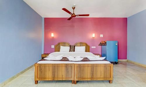 Hotel Ocean Face, BAGA في باغا: غرفة نوم بسرير كبير مع مروحة سقف