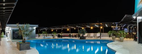 a large blue swimming pool at night at Green Platinum Hotel in Tonsupa