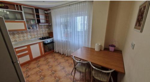 eine kleine Küche mit einem Holztisch und Stühlen in der Unterkunft Уютные апартаменты in Chişinău