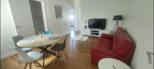 un salon avec une table et un canapé rouge dans l'établissement Appartement entier deux chambres, à Saint-Nazaire