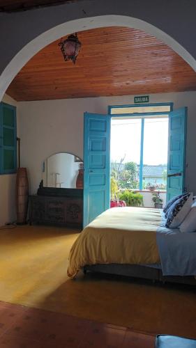 a bedroom with a bed and a large window at Buriti EcoH RNT56521, via Termales Santa Rosa de Cabal in Santa Rosa de Cabal