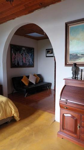 a living room with a couch and a painting on the wall at Buriti EcoH RNT56521, via Termales Santa Rosa de Cabal in Santa Rosa de Cabal