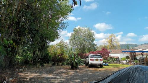a white truck parked in a yard with trees at Buriti EcoH RNT56521, via Termales Santa Rosa de Cabal in Santa Rosa de Cabal