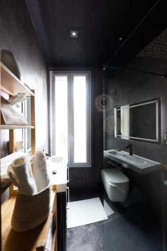 La salle de bains noire est pourvue d'un lavabo et de toilettes. dans l'établissement Le splendide (Chic & Chaleureux), à Vincennes