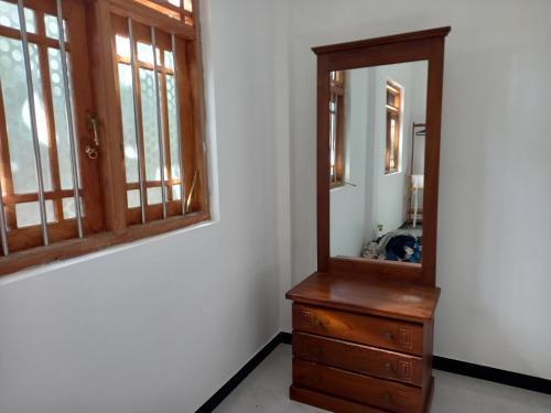 y baño con tocador de madera y espejo. en Chamara home stay, en Ratgama Hegoda