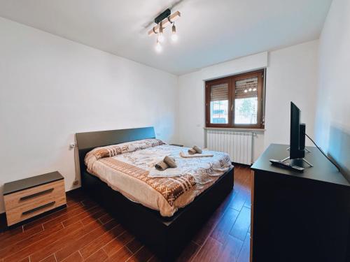 a bedroom with a bed and a desk with a television at Finestra su Villalago in Villalago