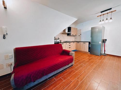 a red couch in a living room with a kitchen at Finestra su Villalago in Villalago