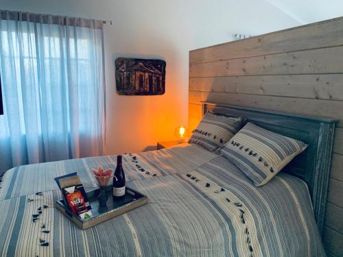 Casita LA في لوس أنجلوس: سرير مع اللوح الأمامي الخشبي وصينية مع زجاجة من النبيذ