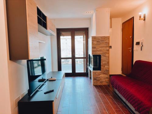 a living room with a red couch and a television at Finestra su Villalago in Villalago