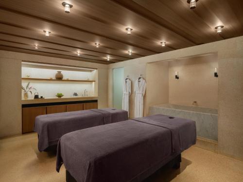 a bathroom with two beds and a bath tub at Hotel Cafe Royal in London