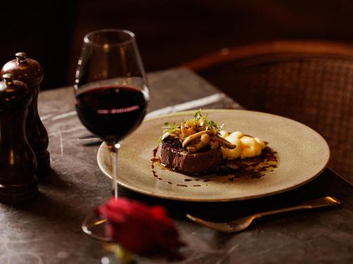 a plate of food next to a glass of wine at Hotel Cafe Royal in London