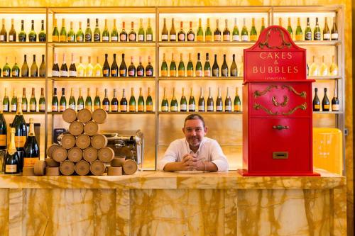 a man sitting at a bar in a wine shop at Hotel Cafe Royal in London