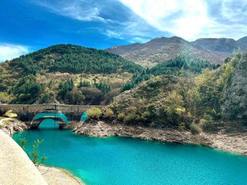 a bridge over a river with blue water at Finestra su Villalago in Villalago