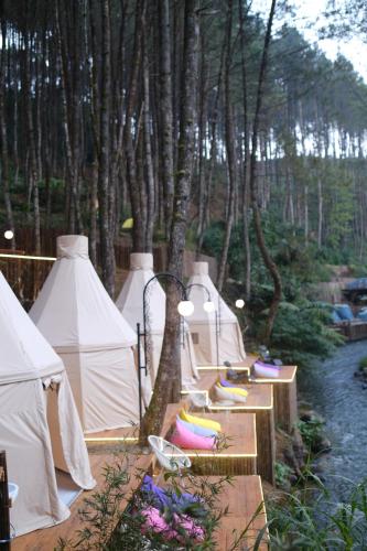eine Reihe weißer Zelte neben einem Fluss in der Unterkunft Regan Luxcamp by Digihub Hospitality in Palayangan