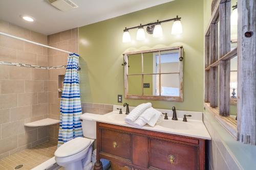 a bathroom with a sink and a toilet and a mirror at Waterfront Lake Gaston Home with Private Dock! in Littleton