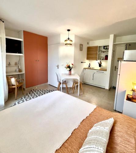 une chambre avec un lit et une table et une cuisine dans l'établissement Le Cocon, à Gréoux-les-Bains