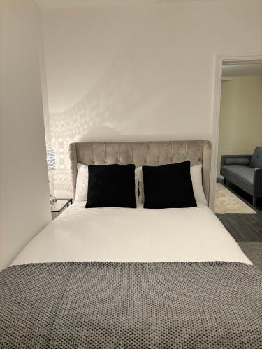 a bedroom with a large white bed with black pillows at Cardiff/Penarth Home in Cardiff
