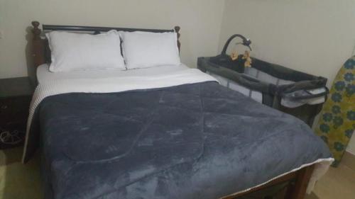 een slaapkamer met een bed met een blauw dekbed bij Casa ozone in Nairobi