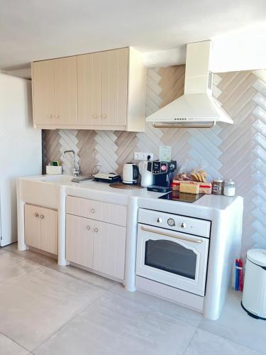 a kitchen with a white stove and a white oven at Gerani Deluxe Houses in Astypalaia Town