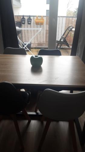 - une table en bois avec 2 chaises et un bol dans l'établissement REPOS EN FAMILLE POUR VISITER PARIS A 15 MIN EN TRANSPORT, à Bois-Colombes