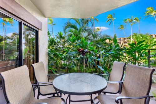 a table and chairs on a balcony with a view at Hono Koa Vacation Club in Lahaina