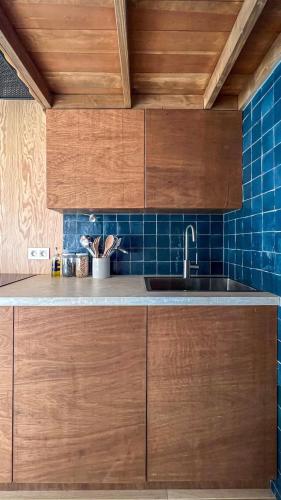 una cocina con armarios de madera y fregadero en Ekko tiny house, en Philippeville