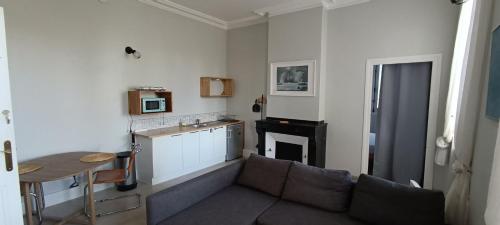 a kitchen and a living room with a couch and a table at Maison Monxanin in Gardouch