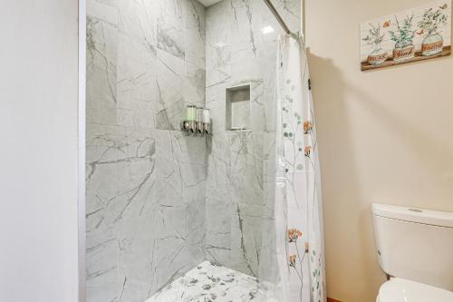 Un baño con ducha con cortina de ducha. en Forest-View Deck and Fire Pit Poconos Escape!, en East Stroudsburg