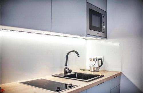 a kitchen with a sink and a microwave at Channel Centrum Deptak PKP PKS -zameldowanie -wymeldowanie bez kontaktowe in Kielce