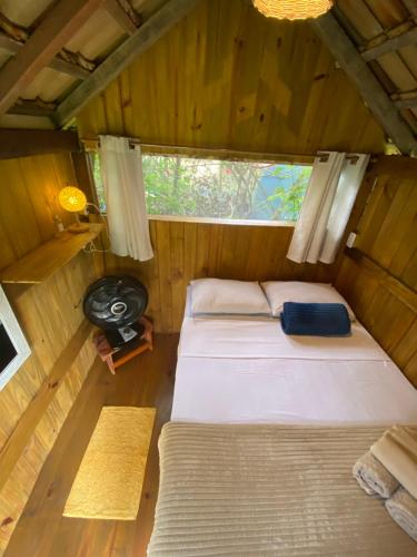 a small room with two beds and a window at Cabana Aloha in Paraty