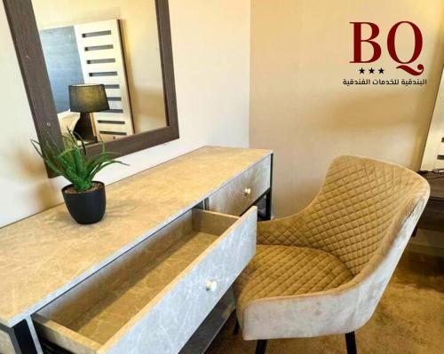 a dressing table with a chair and a mirror at البندقية للخدمات الفندقية BQ HOTEL SUITES in Buraydah