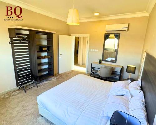 البندقية للخدمات الفندقية BQ HOTEL SUITES في بريدة: غرفة نوم مع سرير أبيض كبير ومكتب