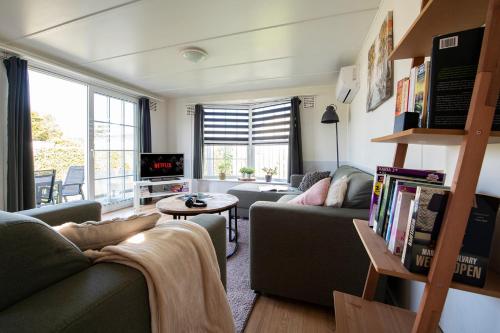 a living room with a couch and a table at 64, Charming Nature Retreat, Near Efteling, with Private Parking & Garden in Oisterwijk